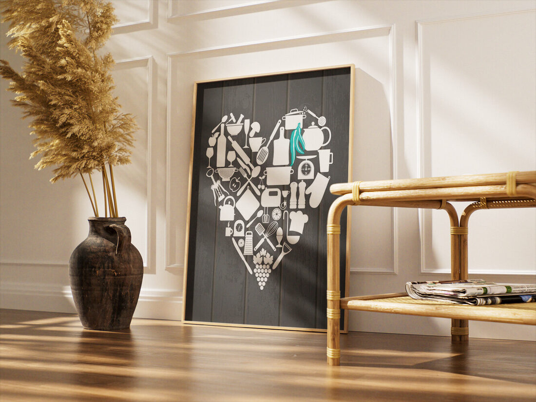 White kitchen utensils and food items like grapes and a wine bottle forming a heart on a dark wood background with teal accents.