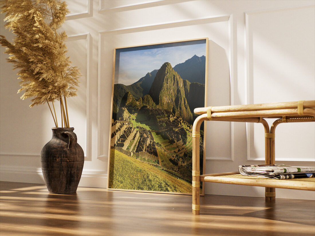 High-angle photograph of Machu Picchu ancient city, lush green terraces, and iconic Huayna Picchu mountain under a blue sky.