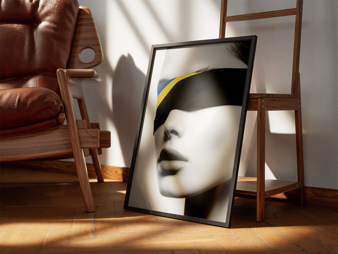 Grayscale image of a blindfolded woman's face with blue and yellow Ukrainian flag colors peeking from under a black blindfold.